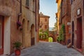 Pienza, Italy Ã¢â¬â May 27, 2017: Beautiful narrow street with sunlight and flowers in the village of Pienza, Italy Royalty Free Stock Photo